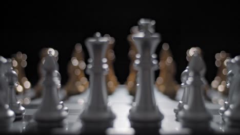 close up sliding shot starting its focus on one side of an ornate chessboard and shifting to the opponent's side