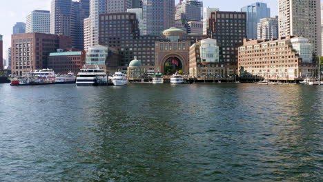 low drone shot approaching boston skyline from boston harbor