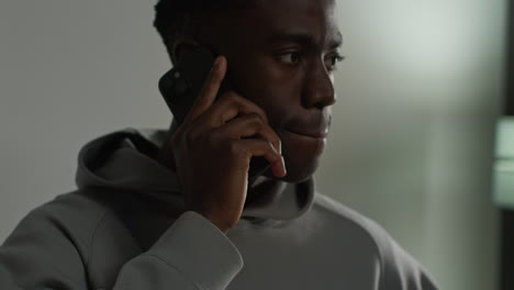 close up of young man at home talking on mobile phone reacting and looking upset after getting bad news