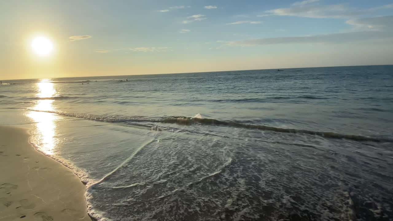 Close-up of the waves of the sea reaching the coast at sunset in the famous beach of Máncora, Peru.