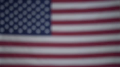 hands of a wanderlust person holding box of saved coins for travel fund with flag of america in blurry background