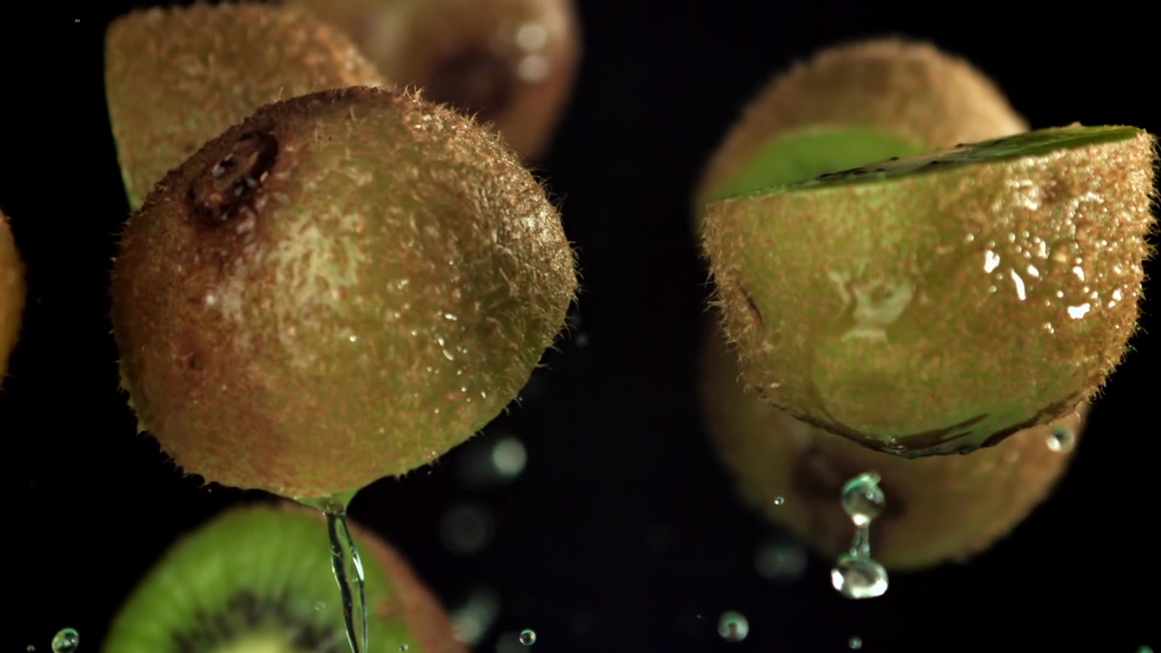 Frische Kiwifrüchte fallen in Zeitlupe ins Wasser und spritzen