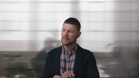 portrait of professional businessman checking wrist watch looking pensive thinking waiting in office workspace background