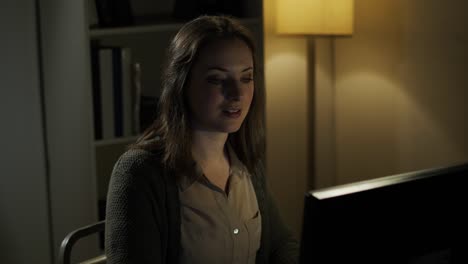 businesswoman works late typing on a computer