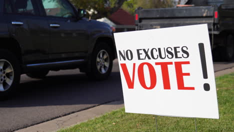 political voter rally sign next to road with cars driving by, no excuses vote