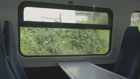 interior view at train's empty window seat window move through countryside in the north of the uk