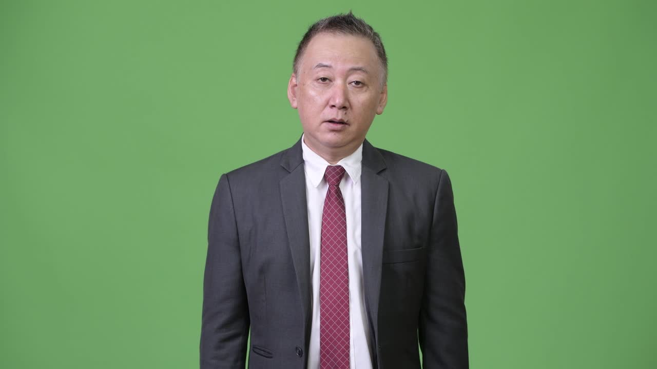 성숙한 일본인 사업가들이 엄지손가락을 올리고 있습니다.