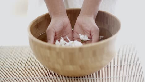 female hands with bowl of aroma water