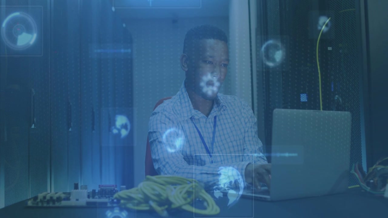 Blue HUD overlays appearing and drifting, mid adult man typing, monitoring network health on laptop