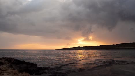 Echtzeitaufnahme-Des-Sonnenaufgangs-In-Qawra,-Malta,-Regnerischer-Tag,-Dunkle-Schwarze-Wolken