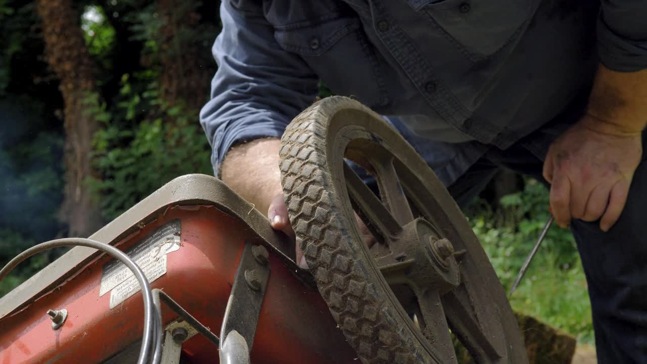 Man working on vintage industrial machinery outdoors