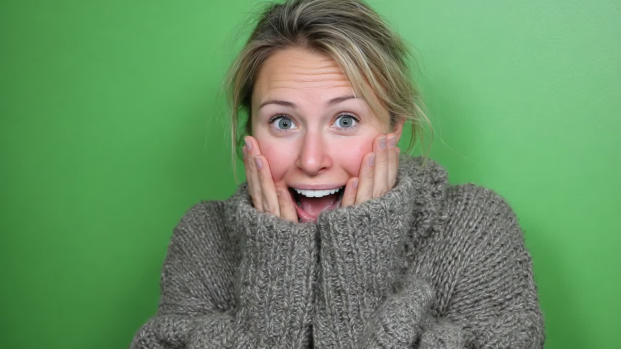 A Woman Expresses Pure Joy and Surprise with Enthusiastic Glee, Hands on Face, Captured Against a Vibrant Green Background Emphasizing Her Delightful Emotions