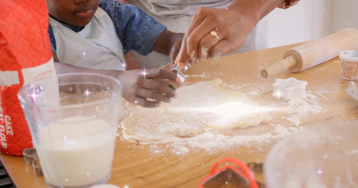 Placing hand on dough dad guiding child kneading for baking pressing star cutter with sparkles