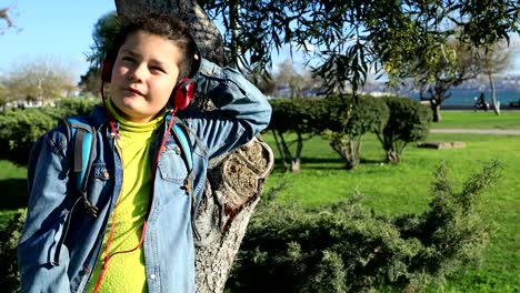 young boy listening to music at the outdoors