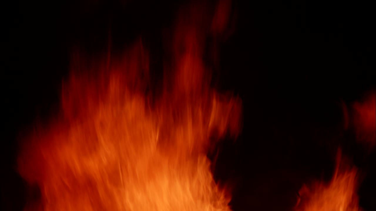 Nærbillede af røde og orange flammer der brænder på sort baggrund