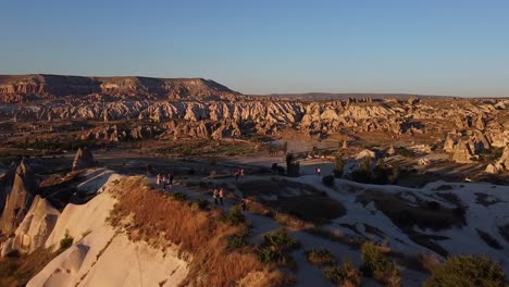 aerial view of a panoramic viewpoint with people watching the sunset above cappadocia