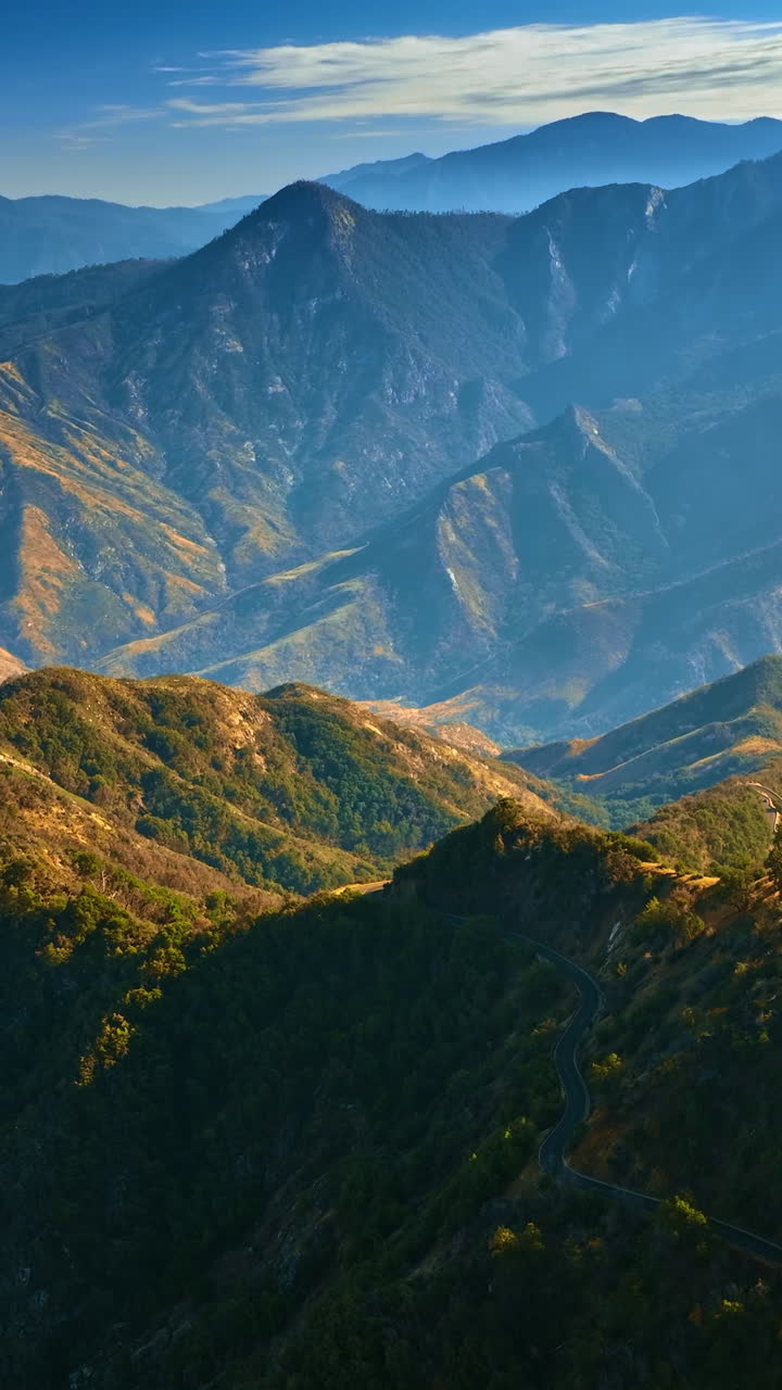 Fascinating view of the mountains in California desert. Approaching rocks covered with greenery. Rocks in blue haze at backdrop. Top view. Vertical video