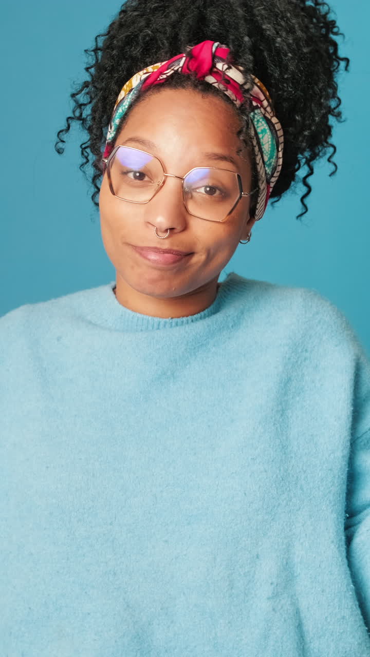 Young Woman with Curly Hair and Glasses Looking at Camera