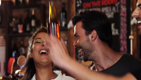 grupo de amigos interactuando mientras brindan botellas de cerveza