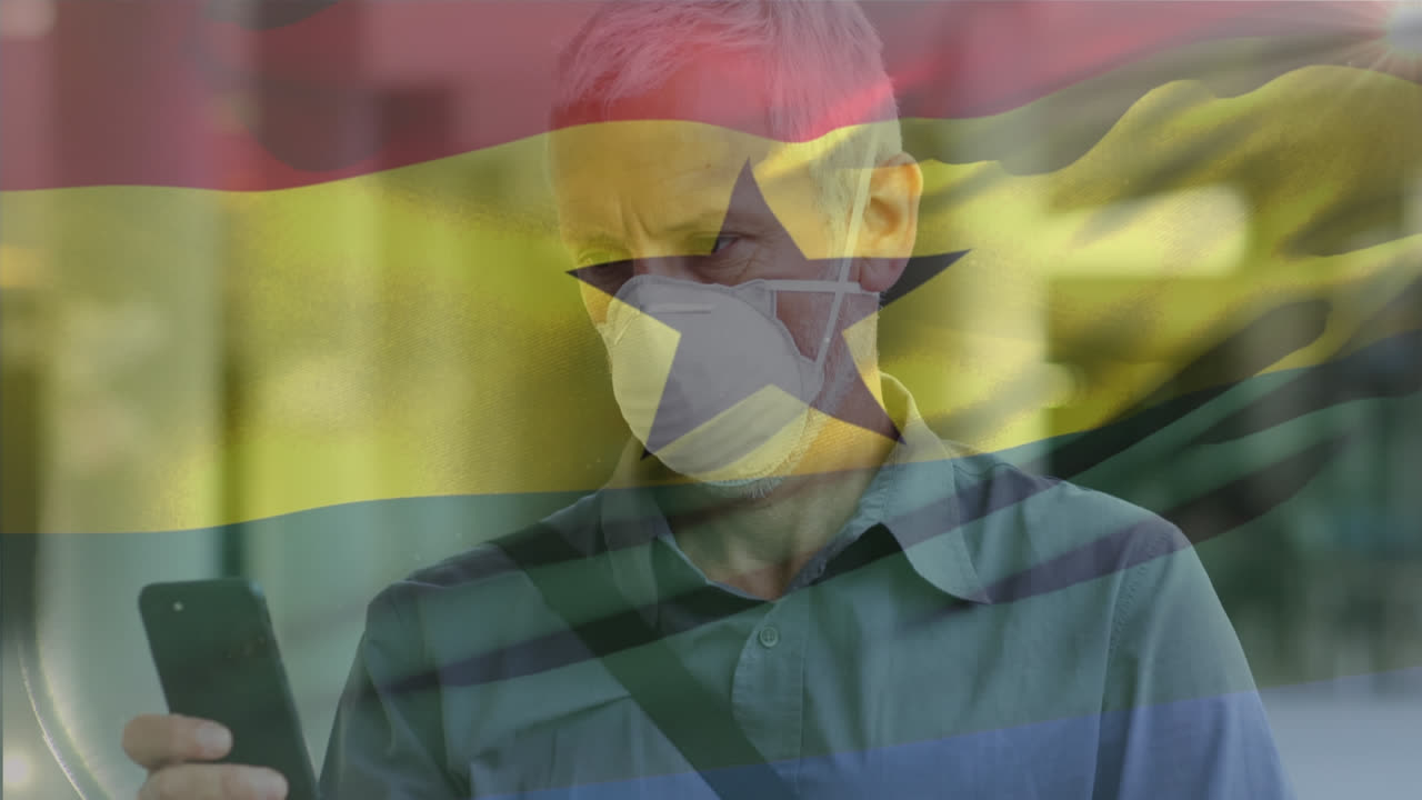 Animazione di bandiera del Ghana che sventola su sfondo di uomo caucasico con mascherina che usa lo smartphone per strada