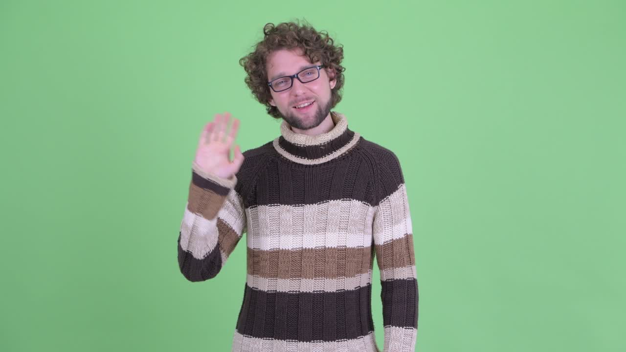 un joven guapo con barba y cabello rizado.