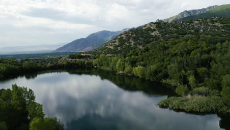 mirror reflections on calm lake on bell canyon trail, sandy utah, usa