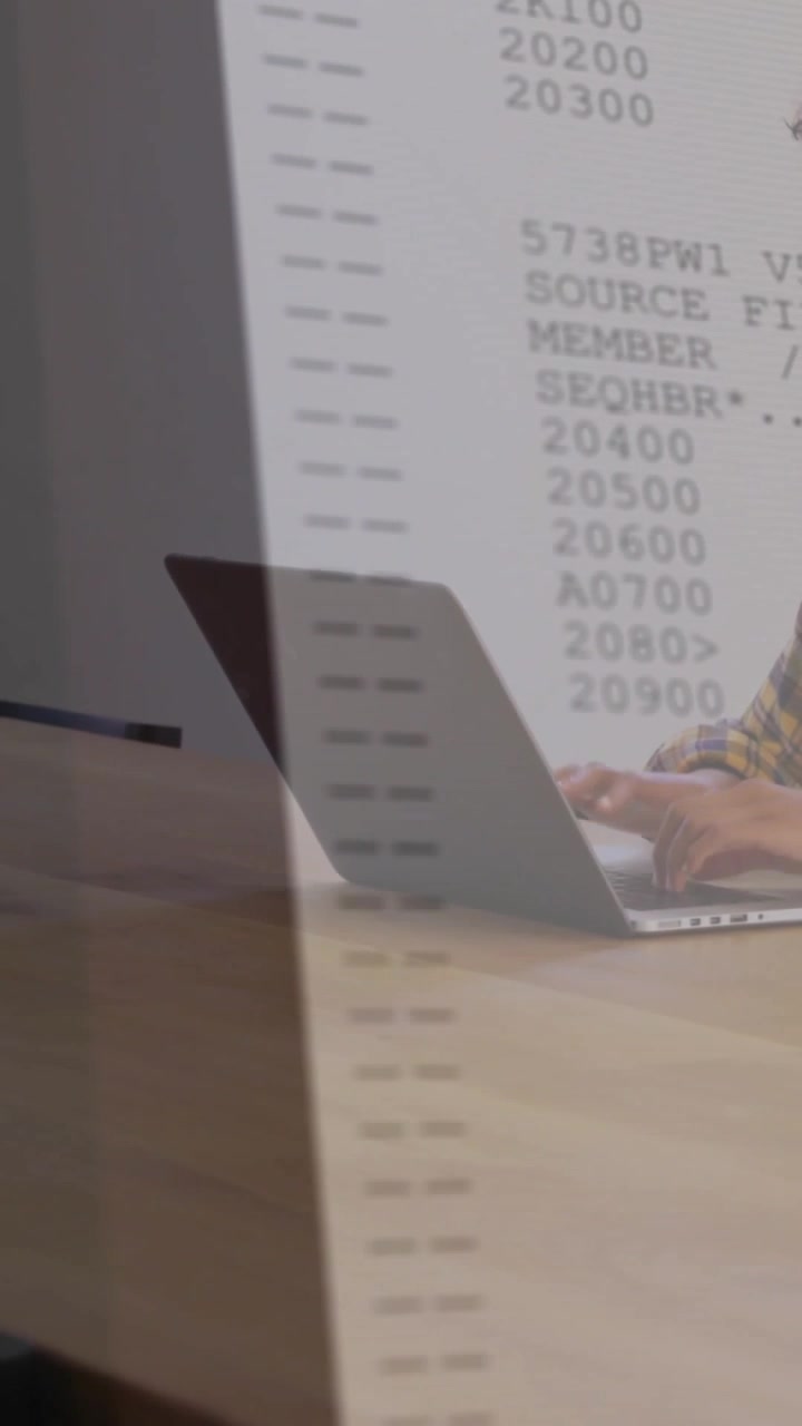 Video verticale: Codice che appare, formando una colonna mentre un programmatore seduto digita su un laptop, mostrando numeri.