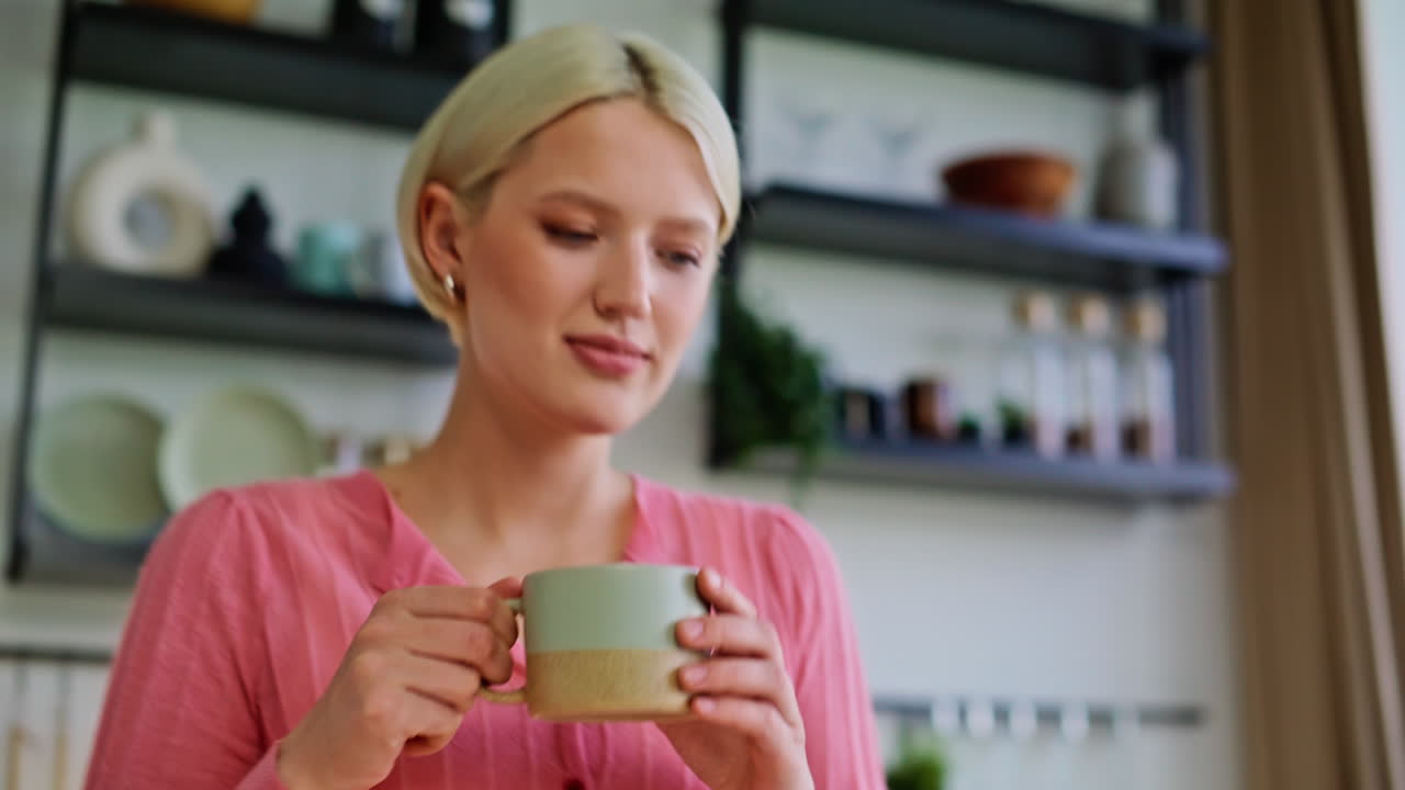 Primo piano di una donna che versa l'espresso, gustandosi il caffè mattutino in una cucina accogliente