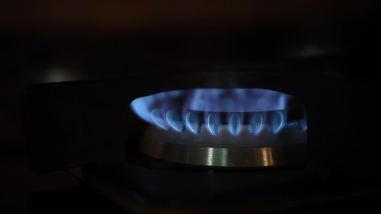 Close-up of a gas burner with a blue flame