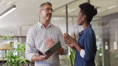 video of happy diverse businessman and businesswoman talking about project