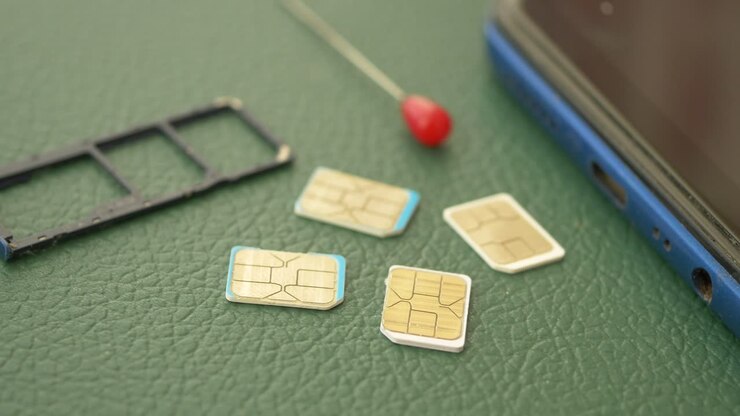 Sim Cards and Sim Tray on a Green Surface