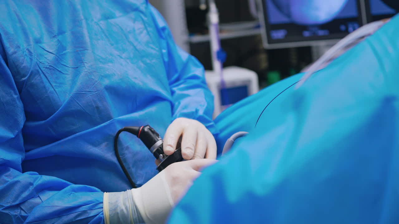 Doctor with new medical equipment. Specialist in medical uniform uses modern instrument during surgery. Close-up.