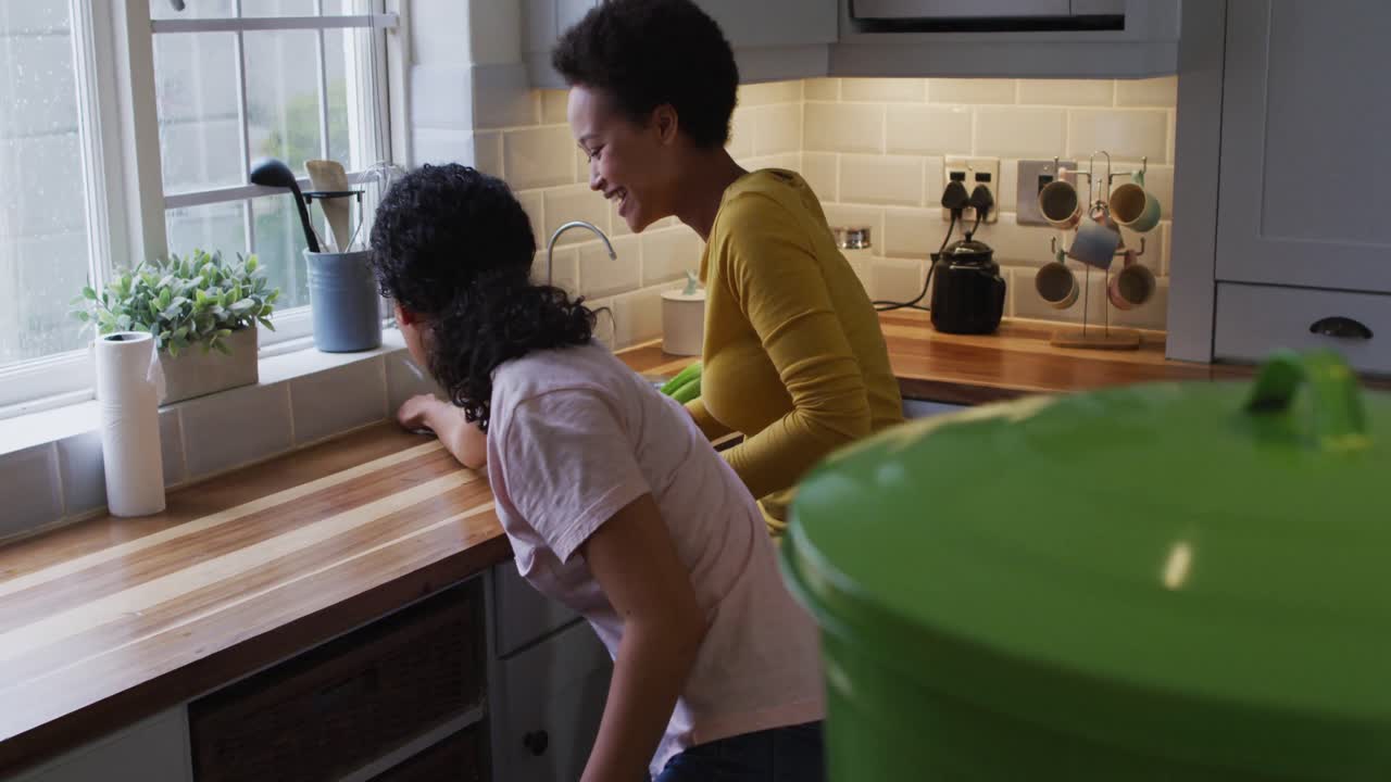 Mixed race lesbian couple and daughter cleaning kitchen