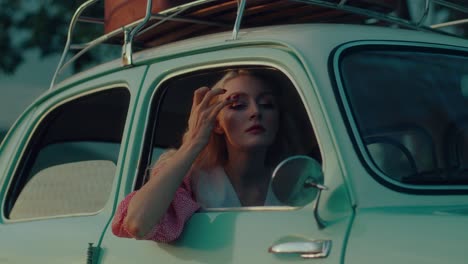 woman adjusting mirror in vintage car