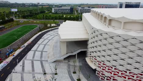 Nach-Links-Verschiebbare-Luftaufnahme-Des-Olympischen-Zentrums-Weihai-Mit-Blick-Auf-Das-Fußballfeld,-China