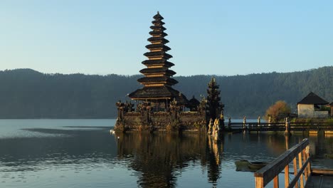 Ascending-slow-motion-shot-of-a-historic-hindu-temple-on-bali-at-volcano-lake-batur-overlooking-the-calm-sea-and-beautiful-landscape-in-indonesia