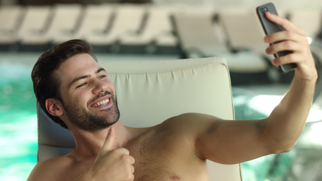 primer plano de hombre sexy haciendo una selfie cerca de la piscina. chico guapo mostrando como gesto