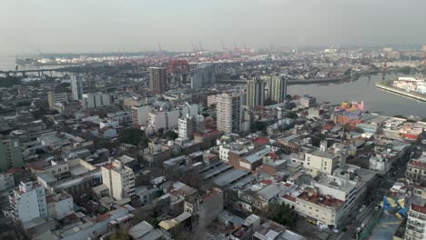 Una-Vista-De-Pájaro-De-La-Boca,-Con-El-Puente-Nicolás-Avellaneda-Y-El-Puerto-De-Buenos-Aires-Al-Fondo