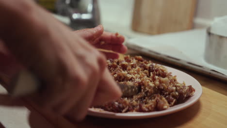 Woman mashing vegetarian fruits mix with knife