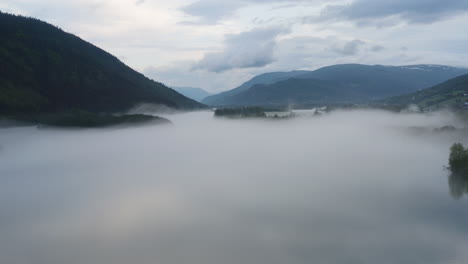 flight over a foggy river. the mist is hanging low over the landscape creating a dark mystical mood over the whole scene.