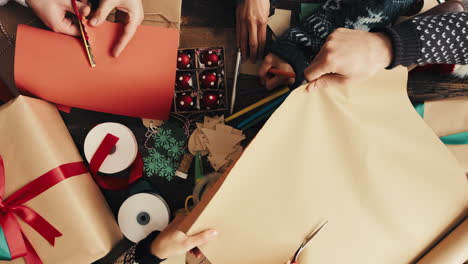 hands wrapping christmas presents arial view