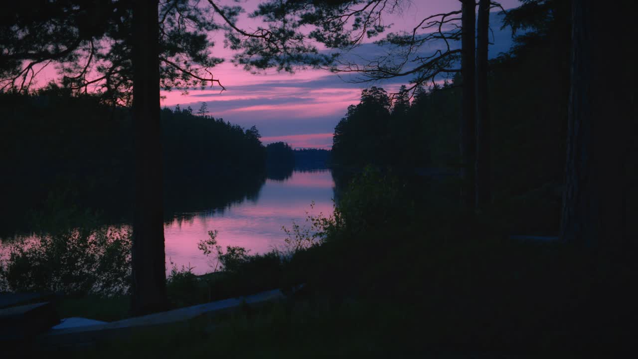 Cielo magico al tramonto che si riflette nel lago di una foresta svedese