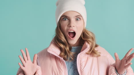 teenage caucasian girl with winter clothes waving to the camera.