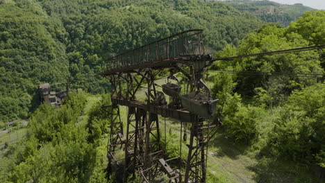 rusty weathered freight ropeway pylon above factory in chiatura valley