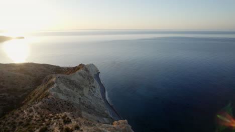 Die-Ruhige-Schönheit-Zyperns-Mit-Dieser-Atemberaubenden-Luftaufnahme,-Die-Den-Sonnenuntergang-über-Dramatischen-Weißen-Klippen-Und-Dem-Ruhigen-Mittelmeer-Einfängt