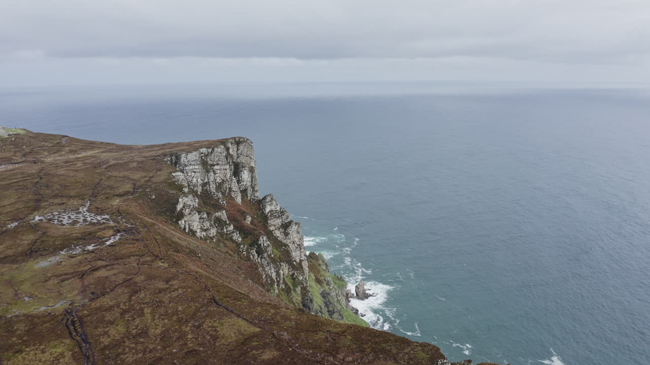 Breathtaking views of the rugged cliffs meet the Atlantic Ocean in County Donegal, showcasing the stunning Irish landscape. Nature's beauty unfolds in this remote area.