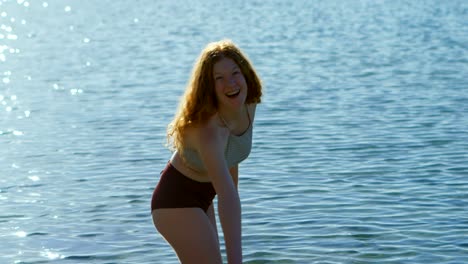 woman playing with water at beach 4k