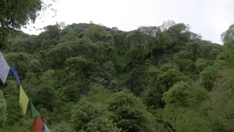 Tibetische-Gebetsfahnen-Im-Nepal-Himalaya-Dschungel,-Annapurna-Gebirge,-Schwenk-Hinüber