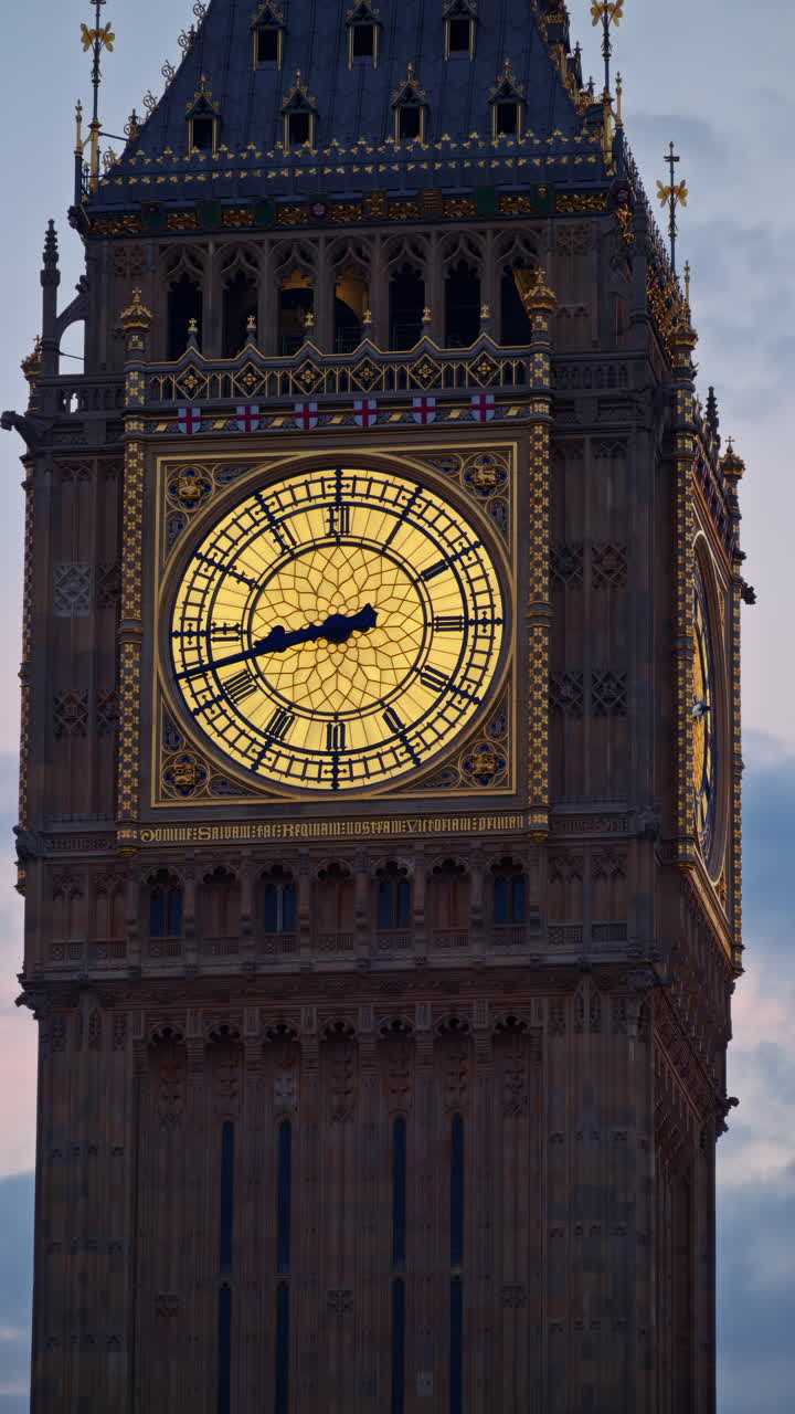 Close-up view of Big Ben illuminated at dusk in London, England. Vertical