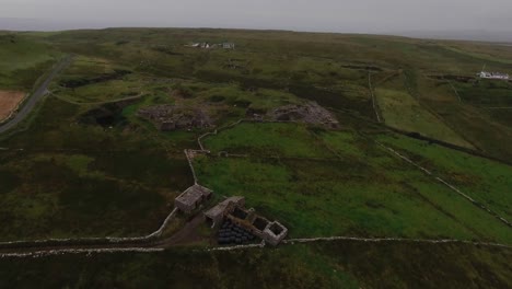 green landscape at dusk in a cloudy day. lands close to the cliffs of moher in ireland. aerial shot at the end of the day.